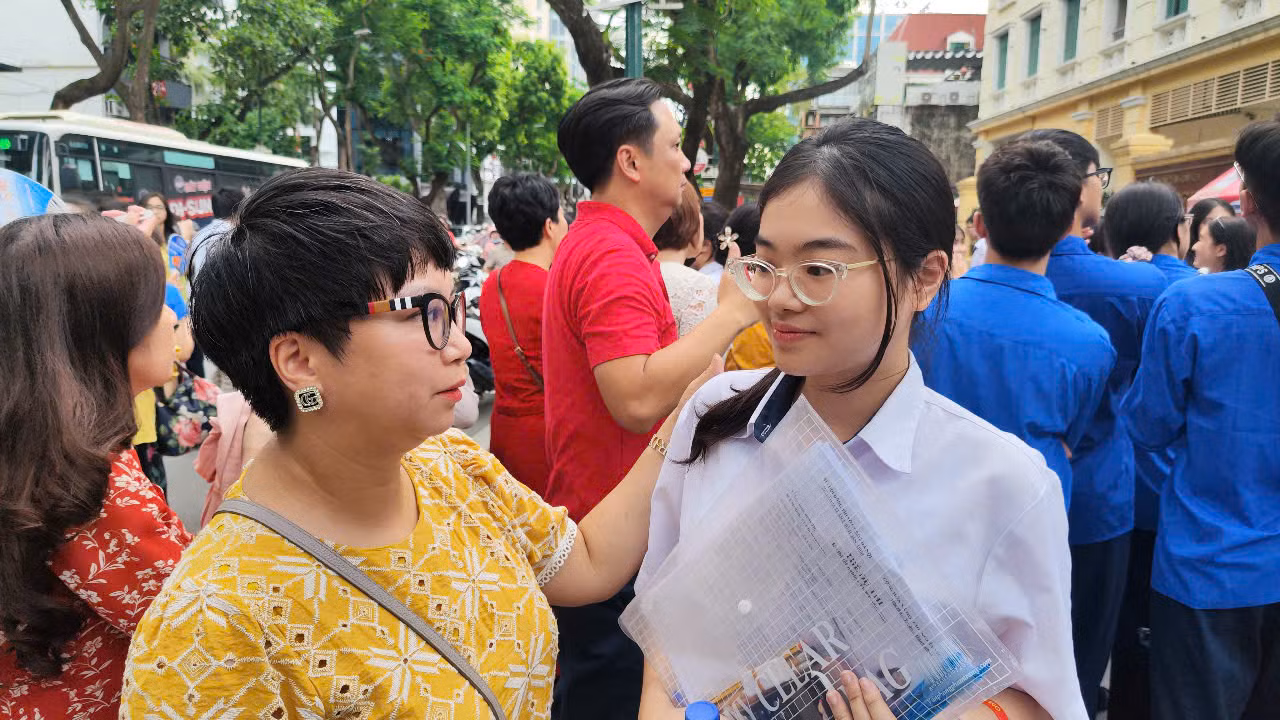 Chị Thu hỏi thăm con gái sau khi hoàn thành kỳ thi. Ảnh: Thúy Hằng.