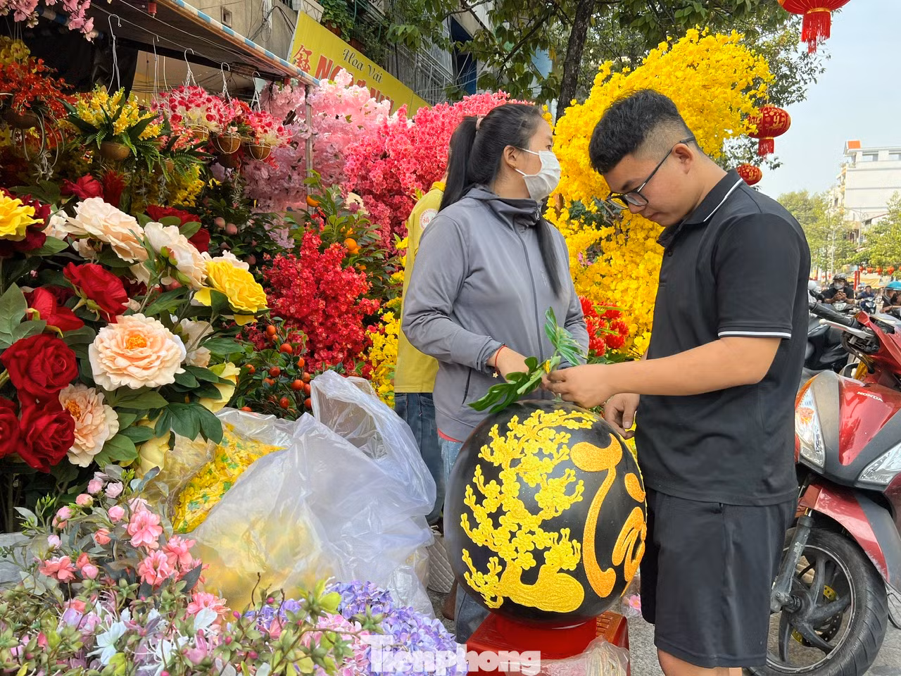 Một tiệm hoa giả chào mời khách hàng một quả dưa hấu khổng lồ được chạm khắc tỉ mỉ cành mai và các câu đối chúc Tết. Đặc biệt chữ Tài được viết kiểu thư pháp, nạm kim tuyến nổi bật. Một tiệm hoa giả chào mời khách hàng một quả dưa hấu khổng lồ được chạm khắc tỉ mỉ cành mai và các câu đối chúc Tết. Đặc biệt chữ Tài được viết kiểu thư pháp, nạm kim tuyến nổi bật.