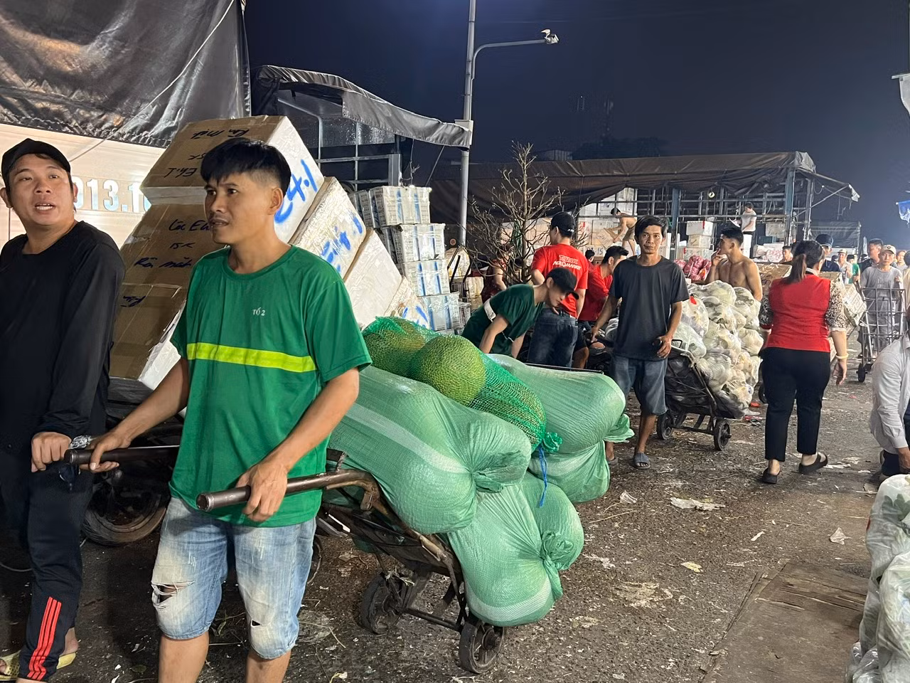 Nhân viên vận chuyển, bốc xếp liên tục làm việc. Do chợ quá đông trong ngày cao điểm nên bị ùn ứ, các nhân viên phải chờ đợi nhau để di chuyển. Nhân viên vận chuyển, bốc xếp liên tục làm việc. Do chợ quá đông trong ngày cao điểm nên bị ùn ứ, các nhân viên phải chờ đợi nhau để di chuyển.