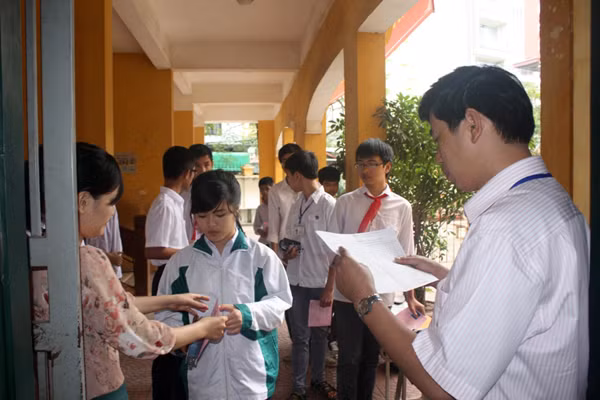 Các giám thị lần lượt đọc tên và kiểm tra thẻ dự thi của từng thí sinh