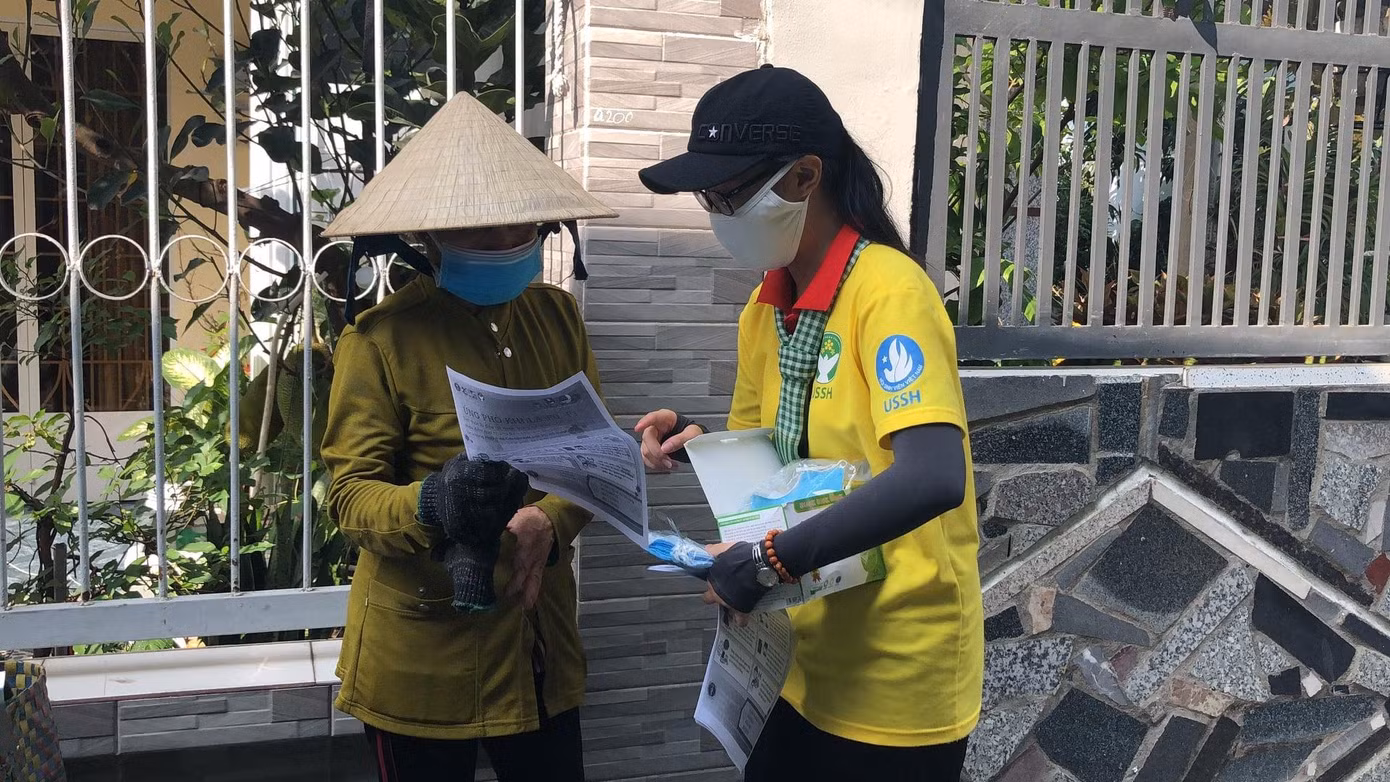 Tặng khẩu trang và phát tờ rơi hướng dẫn phòng, chống dịch bệnh cho người dân ở thị trấn Nhà Bè, do các chiến sĩ khoa Đô thị học thực hiện.