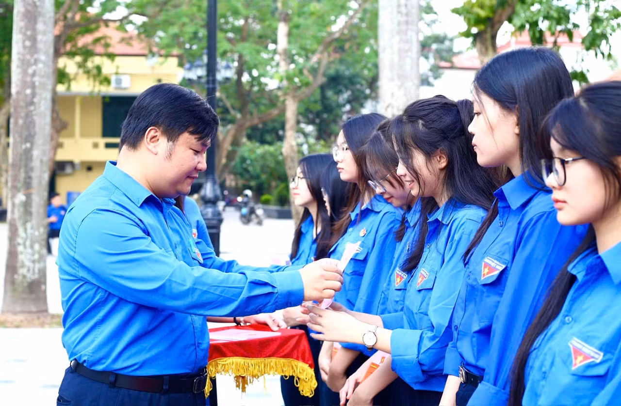 Đồng chí Nguyễn Thái An, Trưởng Ban Tuyên giáo Trung ương Đoàn trao Sổ đoàn và Huy hiệu đoàn cho học sinh lớp Đoàn viên 110 năm Ngày sinh anh Lý Tự Trọng.