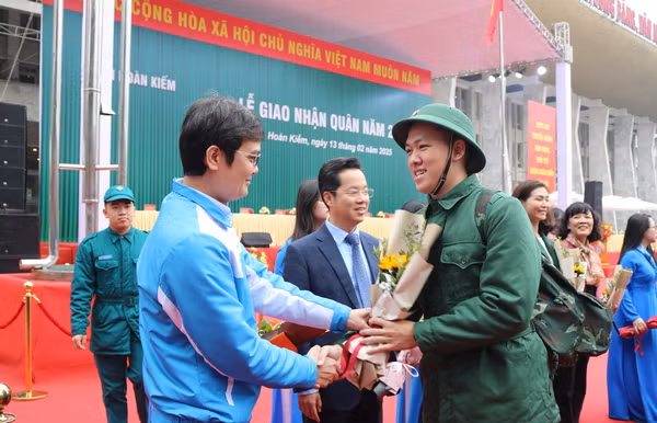 Đồng chí Bùi Quang Huy, Uỷ viên dự khuyết Ban Chấp hành Trung ương Đảng, Bí thư thứ nhất Trung ương Đoàn tặng hoa chúc mừng tân binh Phạm Trung Anh.