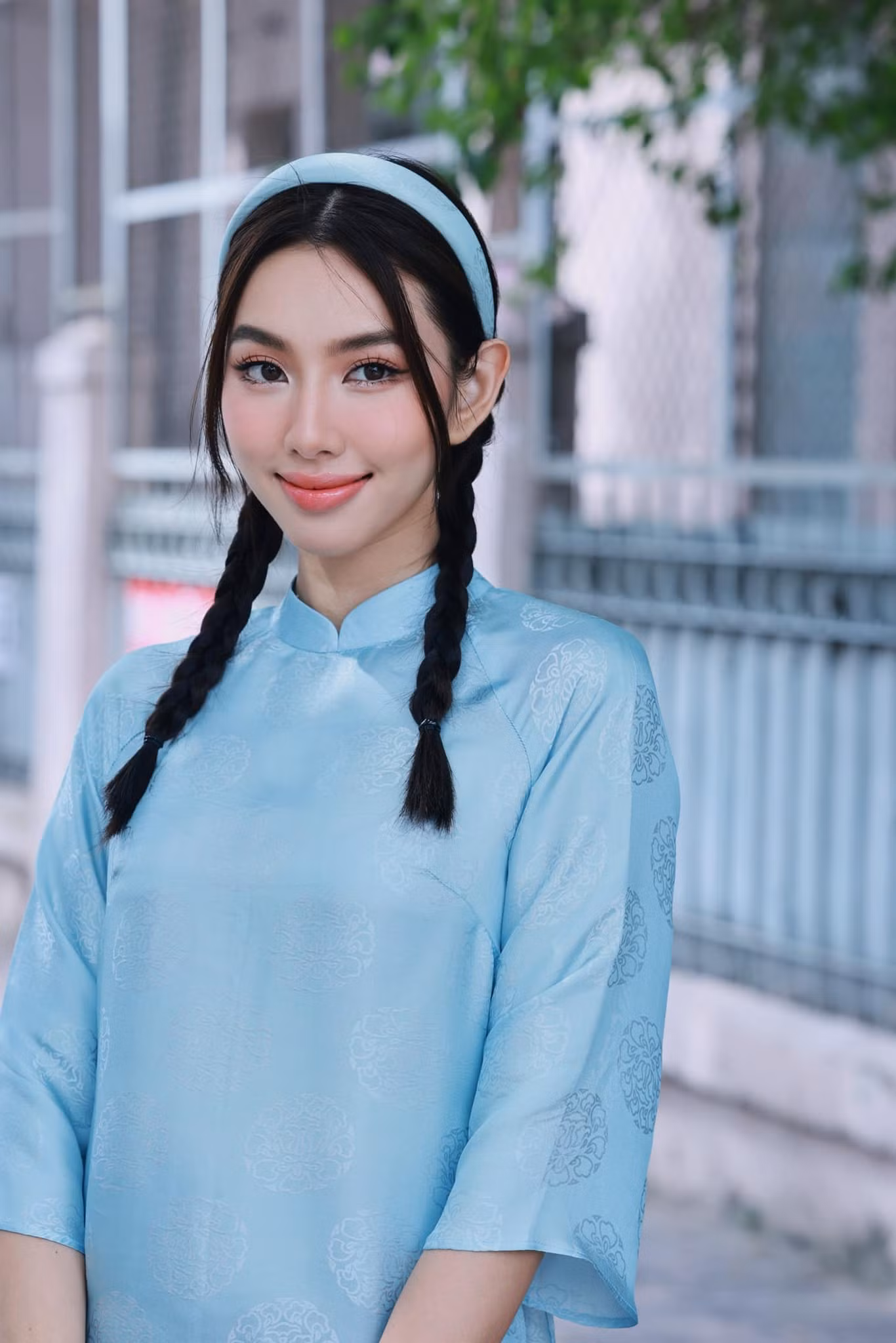 Bộ áo dài cách tân có họa tiết đơn giản kết hợp cùng mấn đội đầu nữ tính.