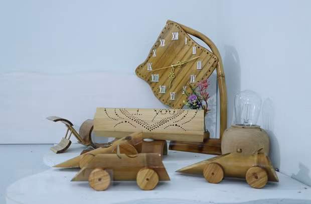Ngoài sản phẩm đèn ống tre, Hà Văn Thời còn sáng tạo ra nhiều sản phẩm khác nhau từ thiên nhiên như đèn trang trí, cốc uống nước, ống đựng văn phòng phẩm, đồng hồ. (Ảnh: Đinh Thùy/TTXVN)