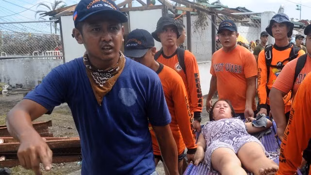 Lực lượng cứu hộ đưa một thai phụ tới trạm y tế dã chiến ở sân bay Tacloban vì cô sắp sinh. Ảnh: Reuters 