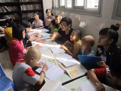 Các TNV đang dạy các em học bài