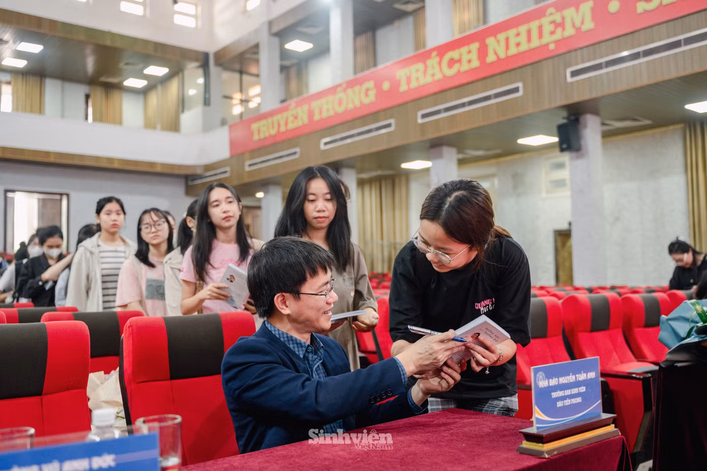 Tác giả, nhà báo Nguyễn Tuấn Anh ký tặng cuốn sách "Trường học hay Trường đời" cho sinh viên Trường Đại học Thương mại.