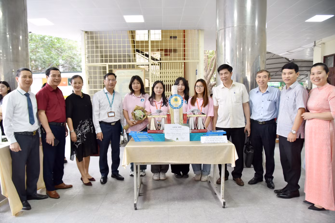 Các thầy trong Ban giám đốc Học viện cùng các thầy cô giáo tham quan mô hình sách đạt giải tại cuộc thi Xếp sách nghệ thuật 2024: Sách mới lời xưa.