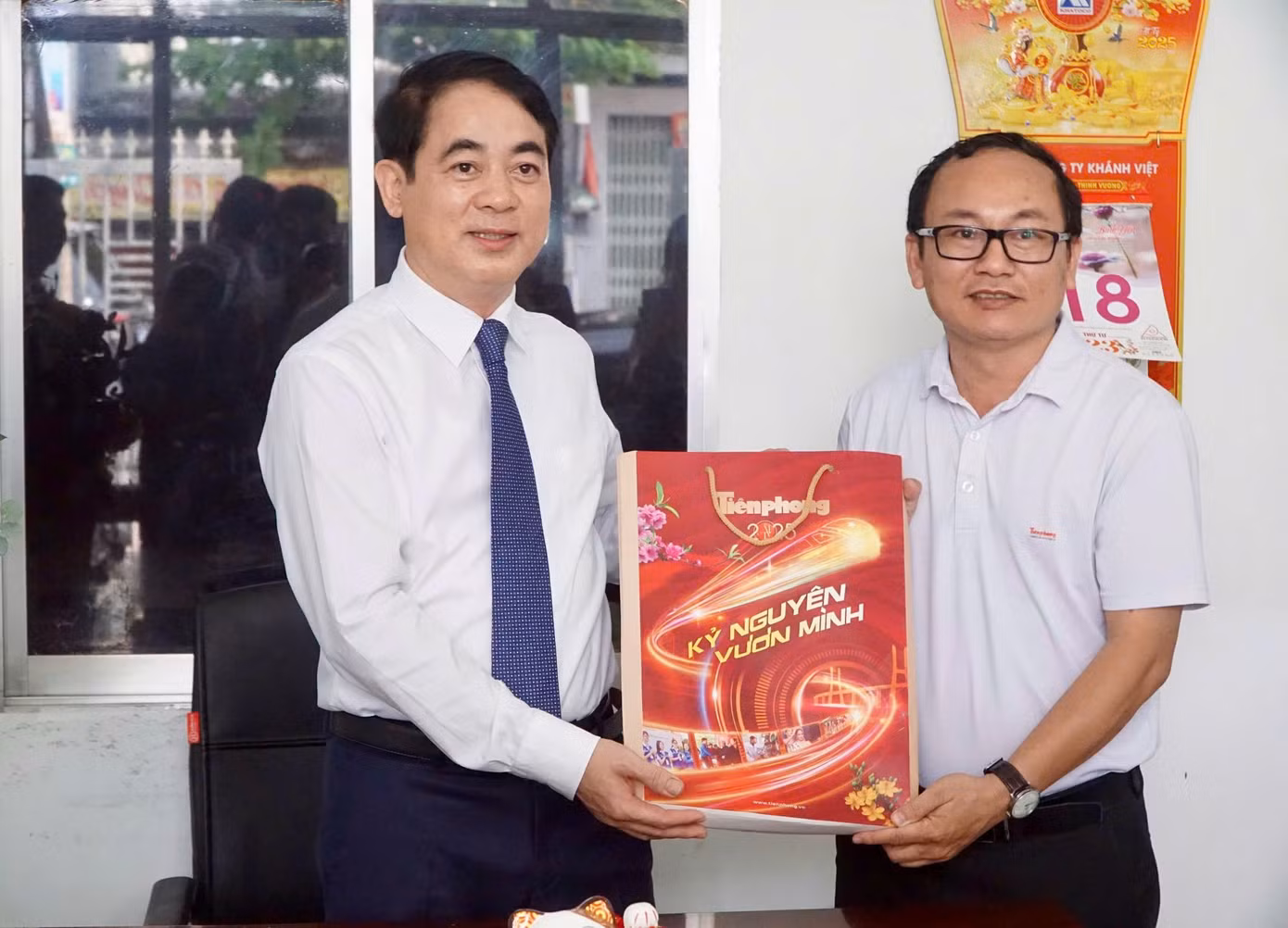 Lãnh đạo Văn phòng đại diện báo Tiền Phong khu vực Tây Nguyên - Nam Trung Bộ gửi tặng ông Nghiêm Xuân Thành (bìa trái) tờ báo Tiền Phong số đặc biệt.