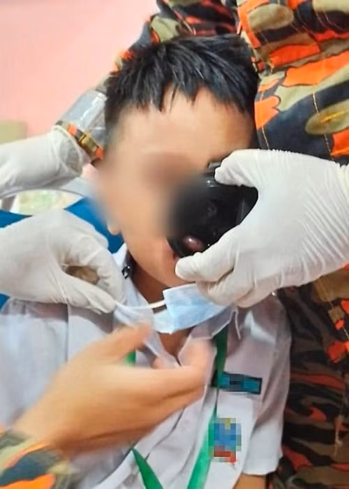 Cậu bé đang được các chú lính cứu hỏa giúp. Ảnh: The Star Online. Cậu bé đang được các chú lính cứu hỏa giúp. Ảnh: The Star Online.