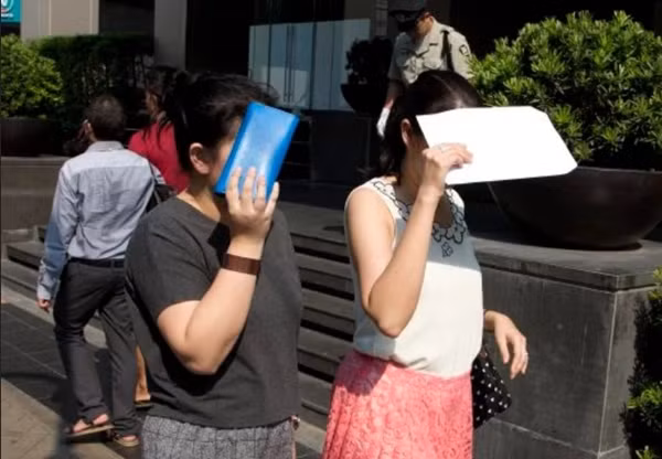 Người dân cố che nắng khi đi bộ ở Bangkok (Thái Lan). Ảnh: AP.