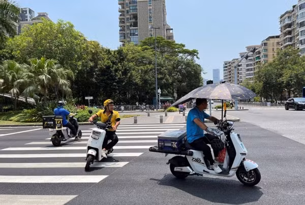 Những người giao hàng đi xe máy dưới cái nóng đã ở mức cảnh báo màu vàng ở Thâm Quyến (Trung Quốc) vào ngày 2/6/2023. Ảnh: David Kirton/ Reuters. Những người giao hàng đi xe máy dưới cái nóng đã ở mức cảnh báo màu vàng ở Thâm Quyến (Trung Quốc) vào ngày 2/6/2023. Ảnh: David Kirton/ Reuters.