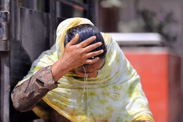 Một phụ nữ dội nước lên đầu cho đỡ nóng ở Dhaka (Bangladesh). Ảnh: Habibur Rahman/ Alamy Live News. Một phụ nữ dội nước lên đầu cho đỡ nóng ở Dhaka (Bangladesh). Ảnh: Habibur Rahman/ Alamy Live News.