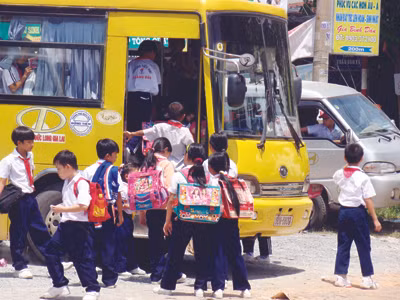 Phụ huynh phải chi thêm tiền cho dịch vụ đón con đi học Ảnh: Đức Minh
