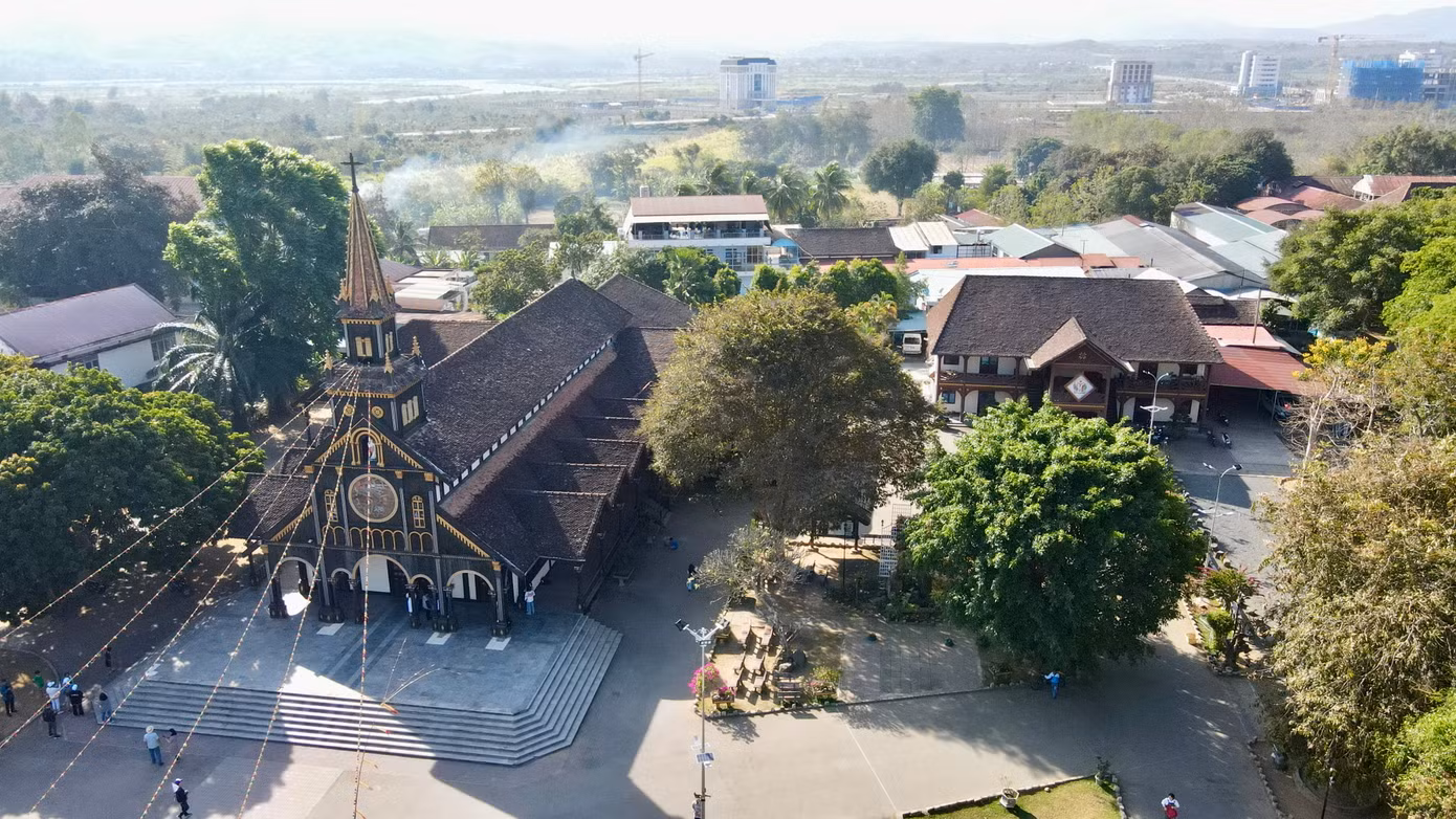 Mặt tiền nhà thờ có một tháp chuông 4 tầng cao 24 m nằm chính giữa, hành lang hai cánh rộng và dài. Bên cạnh đó các mái nhô cao, dốc như mái nhà rông của người Ba Na được đỡ chắc chắn bằng hàng cột gỗ tròn. Ảnh: Khả Hưng.
