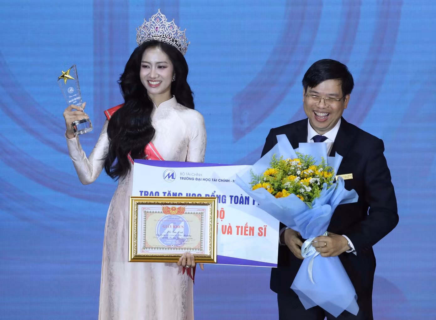 Hoa hậu Hà Trúc Linh đón nhận học bổng từ thầy Hiệu trưởng - PGS.TS Phạm Tiến Đạt. Ảnh: Duy Anh - Phạm Nguyễn - Dương Triều.