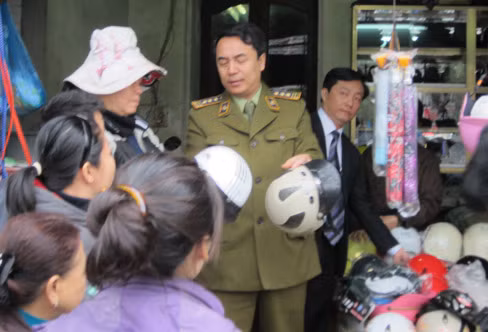 Ông Trần Hùng, Phó Cục trưởng Cục Quản lý thị trường trực tiếp giải thích cho người dân về mũ bảo hiểm không đạt chất lượng. Ảnh: V.S