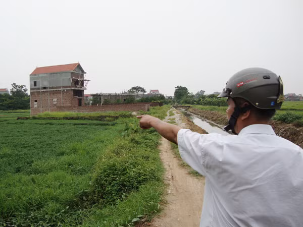 Ông Đặng Khải Hòa, cán bộ địa chính xã Đức Giang chỉ những ngôi nhà không phép xây trên đất nông nghiệp