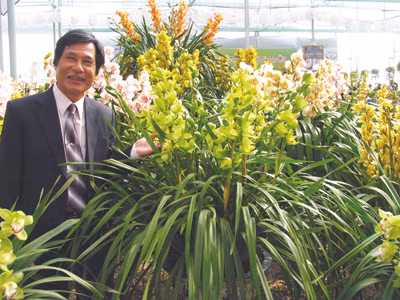 Nghệ nhân Đoàn Văn Quỳnh bên sản phẩm hoa lan của mình. Ảnh: Kim Anh