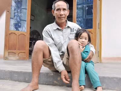 Ông Thuận bên cháu nội sau một ngày lũ rút đi