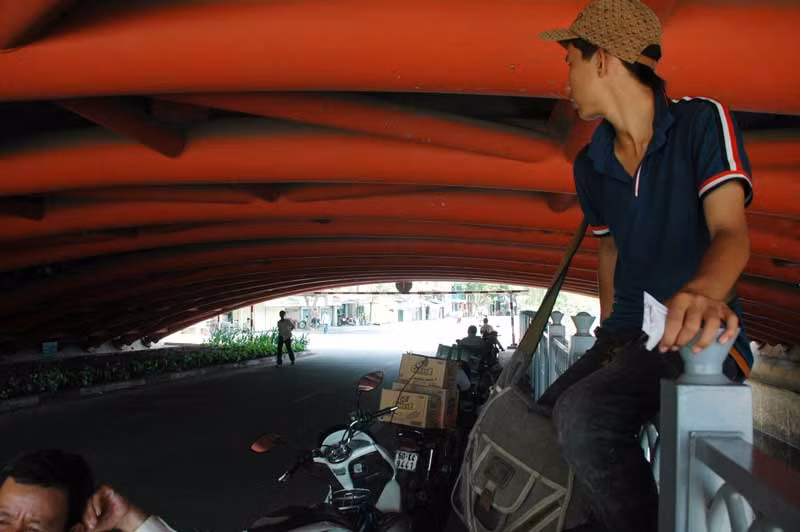 Em Hồ Anh Tuấn, 15 tuổi, quê ở Kỳ Anh, Hà Tĩnh, bỏ học vào Nam bán vé số đã được 2 năm nay. Sau một buổi trưa lê la khắp các con đường, Tuấn chỉ còn 3 vé. “Tranh thủ bán thêm buổi trưa, nghỉ một tí rồi đi lấy thêm để bán tiếp”, Tuấn nói. Gầm cầu Công Lý là nơi tránh nóng lý tưởng cho những người bán vé số, chở hàng, chạy xe ôm… nghỉ ngơi