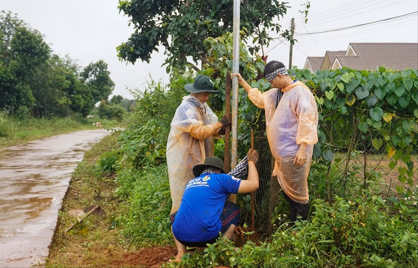 Bất chấp mưa gió, các sinh viên tình nguyện nỗ lực hoàn thiện hệ thống thắp sáng đường làng