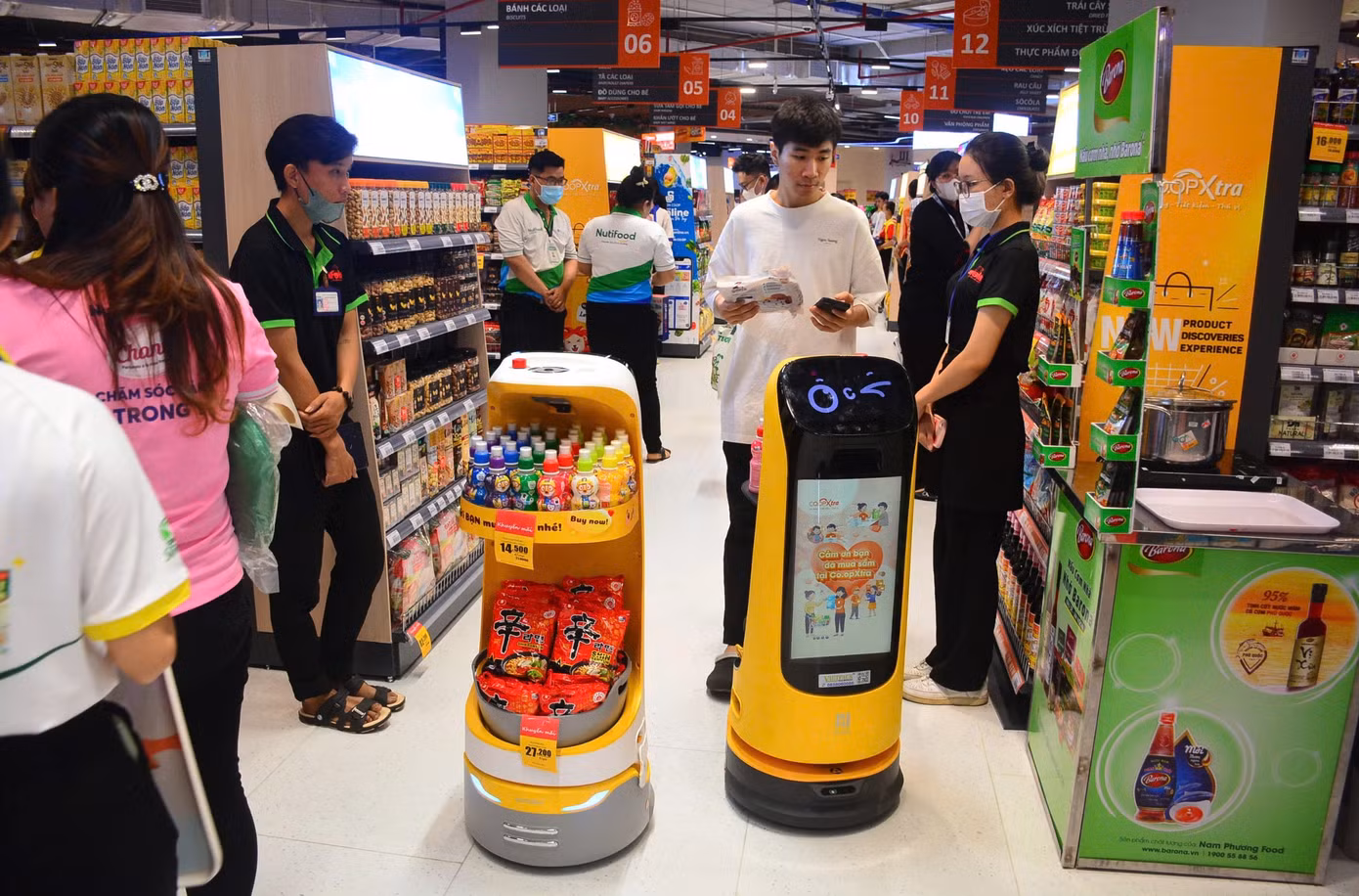 Khách hàng thích thú khi được robot tiếp thị phục vụ trong siêu thị ảnh: U.P Khách hàng thích thú khi được robot tiếp thị phục vụ trong siêu thị ảnh: U.P