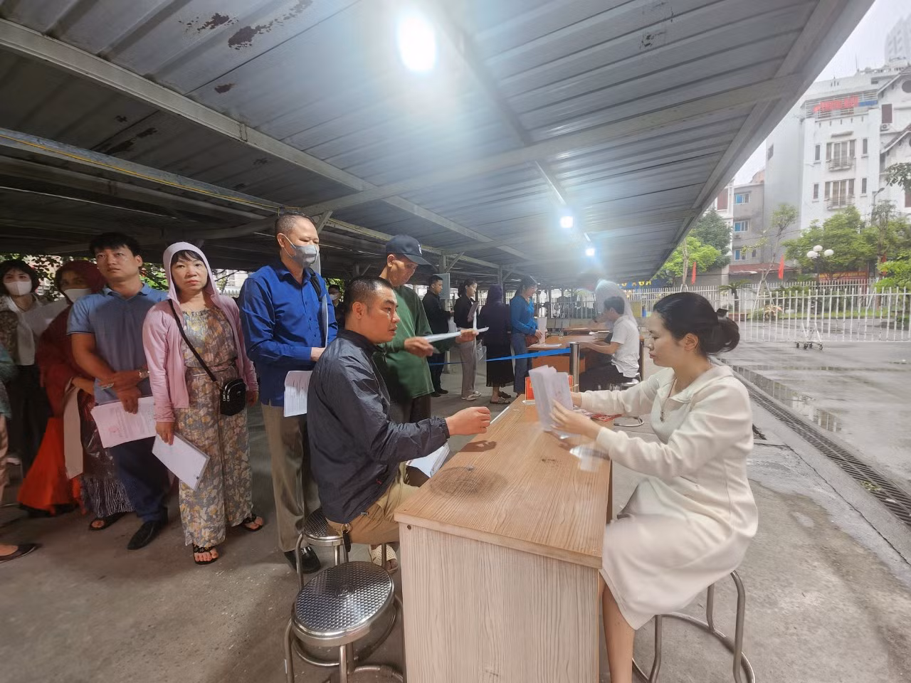 Cán bộ của đơn vị kiểm tra lại hồ sơ, giấy tờ của người dân trước khi vào lấy số. Cán bộ của đơn vị kiểm tra lại hồ sơ, giấy tờ của người dân trước khi vào lấy số.