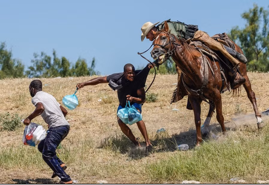 23. Lính biên phòng Mỹ cưỡi ngựa đang cố chặn một người di cư Haiti chạy vào đồn điền bên bờ sông Rio Grande gần cây cầu quốc tế ở Del Rio, bang Texas, ngày 19/9. (Ảnh: Getty Images)