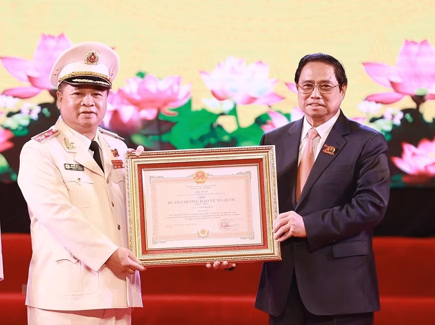 Thủ tướng Phạm Minh Chính trao Huân chương Bảo vệ Tổ quốc hạng Nhất cho lực lượng An ninh Kinh tế. (Ảnh: Dương Giang/TTXVN)
