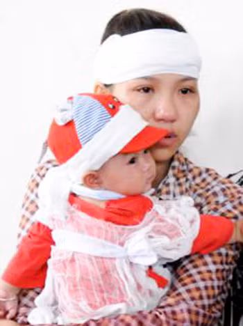 Vợ nạn nhân bế đứa con 5 tháng tuổi tới phiên tòa