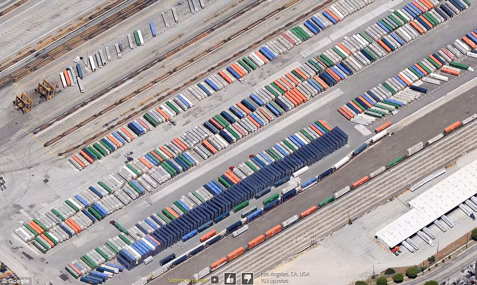Hàng loạt xe tải đang xếp hàng ở một nhà kho tại Los Angeles. Nhìn trên cao xuống như những chiếc bút chì màu. 