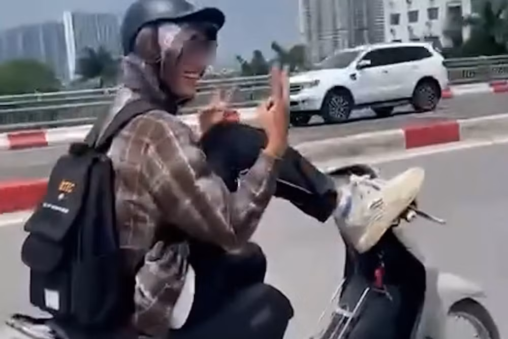 Hình ảnh nam thanh niên dùng chân lái xe máy. Ảnh chụp màn hình
