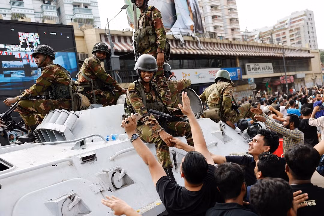 Người biểu tình bắt tay binh sĩ ở Dhaka. (Ảnh: Reuters)