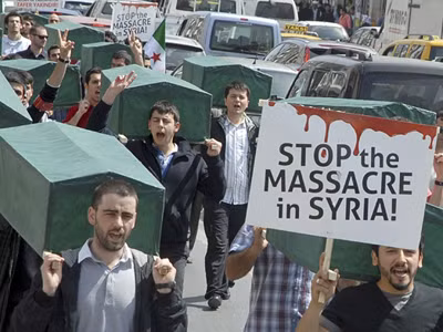 Hơn 70.000 người thiệt mạng từ khi xung đột giữa quân đội Syria và lực lượng nổi dậy bùng phát tháng 3/2011 (Trong ảnh: người biểu tình mang biểu tượng quan tài và tấm biển “Chấm dứt thảm sát ở Syria”). Ảnh: Alarabiya