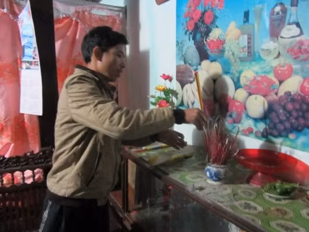 Anh Hà thắp nén hương trước bàn thờ tổ tiên. Anh Hà thắp nén hương trước bàn thờ tổ tiên