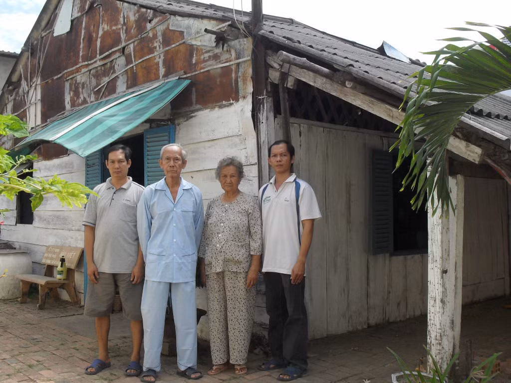 Vợ chồng bà Hương cùng con bên ngôi nhà sinh sống hơn 30 năm, từ khi bị thu hồi đất. Ảnh: Tuấn Anh.