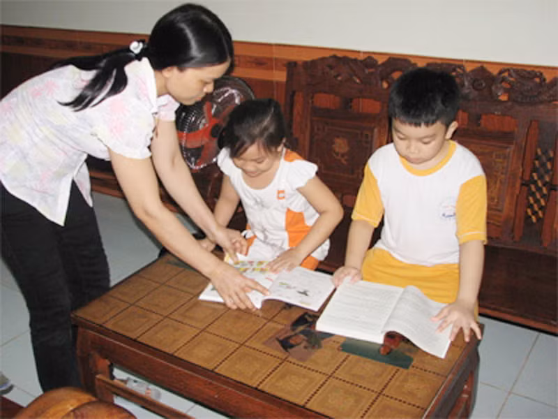 Chị Mai chăm con học ở nhà trong khi anh Phú làm nhiệm vụ trên biển xa