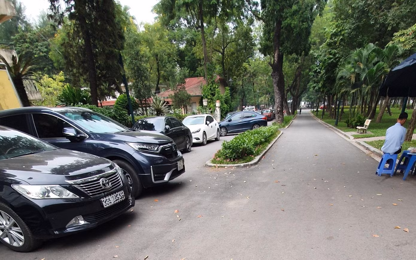 Phía trong công viên, dưới lòng đường, hàng trăm ô tô đỗ chiếm quá nửa lòng đường. Thậm chí, có chỗ ô tô đỗ ngang đường.