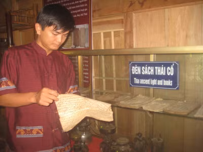 Kiều Văn Kiên bên những cuốn sách chữ Thái cổ. Ảnh: Duy Ngợi. Kiều Văn Kiên bên những cuốn sách chữ Thái cổ. Ảnh: Duy Ngợi.
