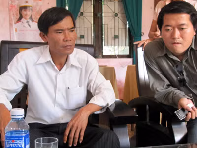 Ông Trần Ngọc Quang, cán bộ xã (bìa trái), nhớ vanh vách tên nhiều người chết vì các bệnh ung thư 