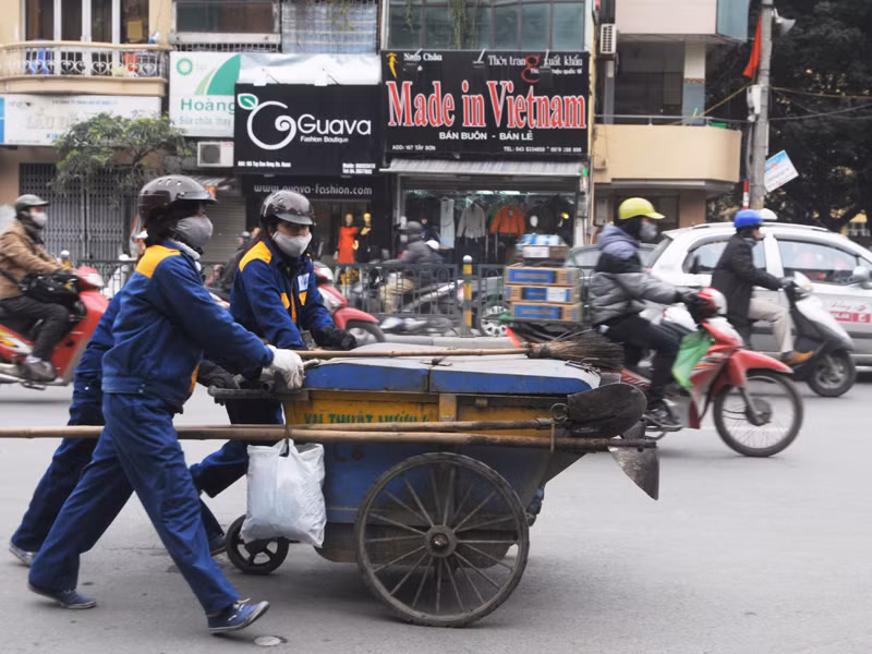 Những chị lao công vẫn miệt mài dọn rác trên các tuyến phố Hà Nội. Ảnh: Tuấn Nguyễn