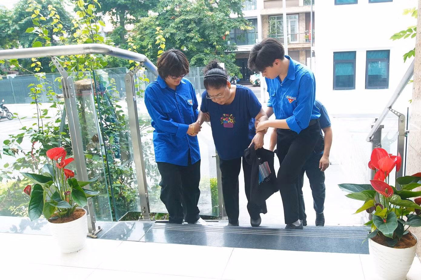Một người lớn tuổi đến làm thủ tục hành chính công được các tình nguyện viên giúp đỡ.