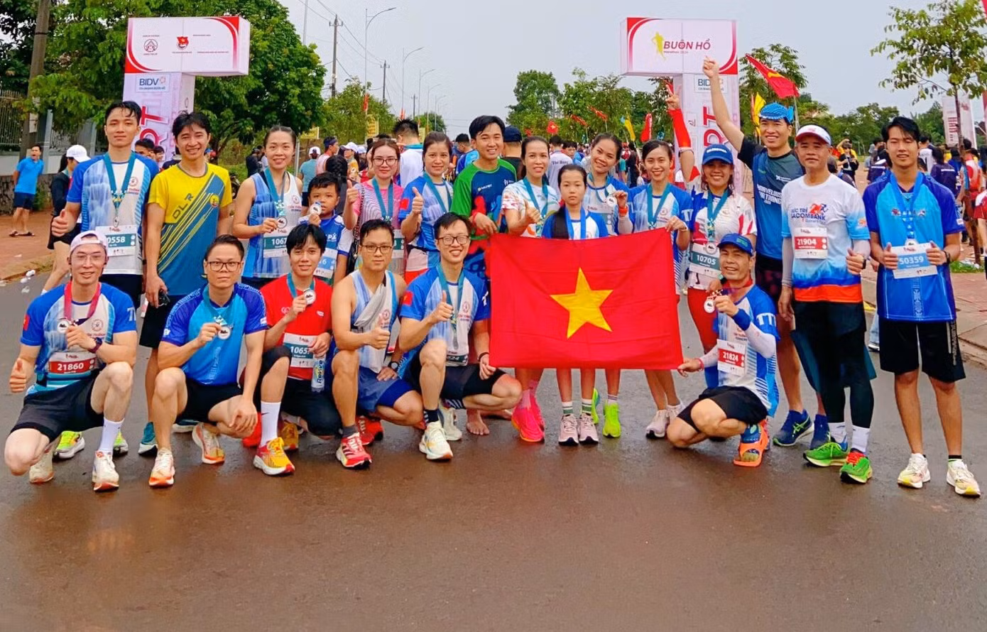 Các vận động viên chụp ảnh kỷ niệm bên lá cờ Tổ quốc