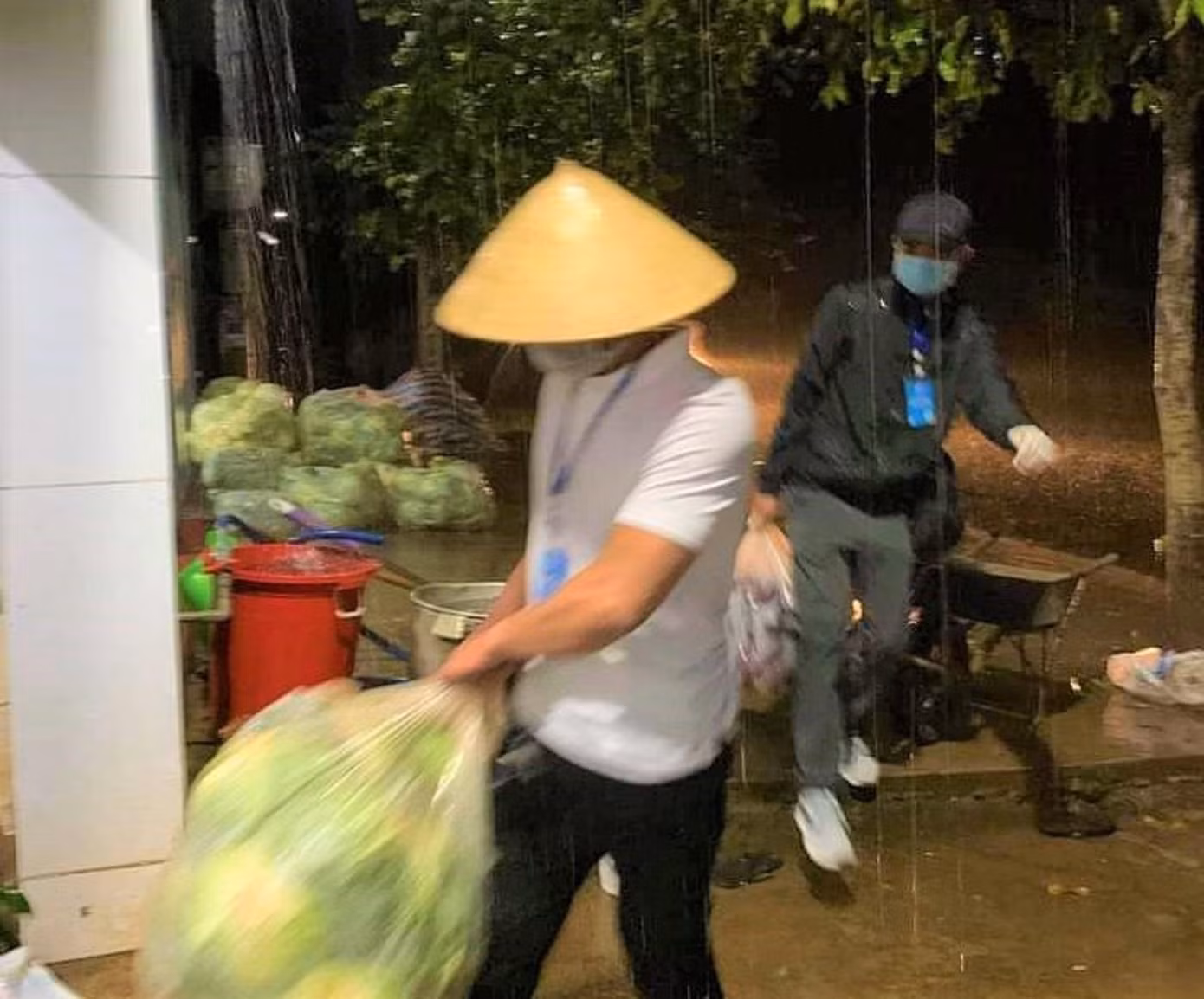 Tình nguyện viên đội mưa vận chuyển thực phẩm tặng người dân