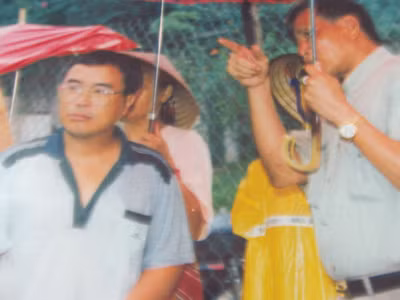 Ông Bùi Văn Sướng (cầm ô bìa phải) theo dõi quá trình tìm hài cốt