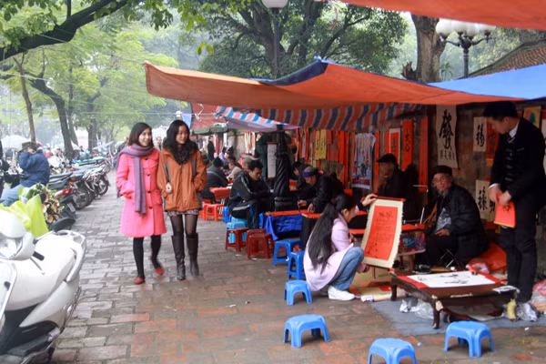Mặc dù lất phất mưa nhưng phố ông đồ - gần Văn Miếu vẫn thu nhộn nhịp khách đến 