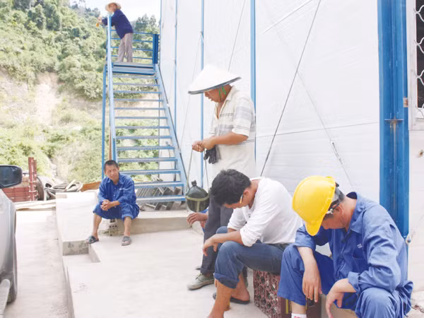 Nhóm công nhân Trung Quốc ngồi tán chuyện trên công trường xây dựng Thủy điện sông Bung. Ảnh: Nam Cường