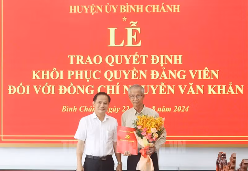 Phó Bí thư Thường trực Huyện ủy, Chủ tịch HĐND huyện Bình Chánh Phạm Văn Lũy trao quyết định khôi phục quyền đảng viên cho ông Nguyễn Văn Khẩn. Ảnh: Thành ủy TPHCM